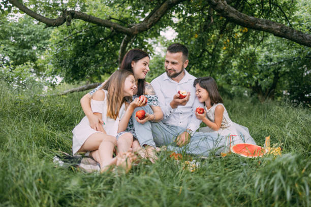 istock Positive parents with two daughters tasting red apples 1328719975