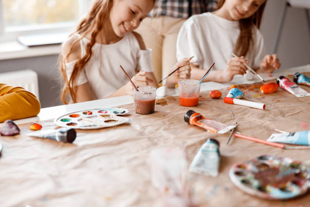 istock Smiling schoolgirls making art painting using water colors 1328720421
