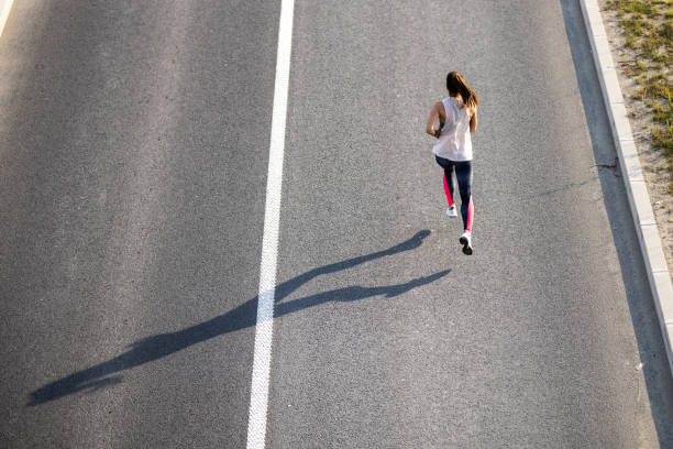 istock Young woman jogging on the road 1328720453