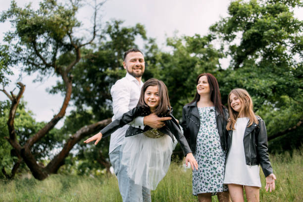 istock Positive parents with two daughters relaxing at garden 1328721617
