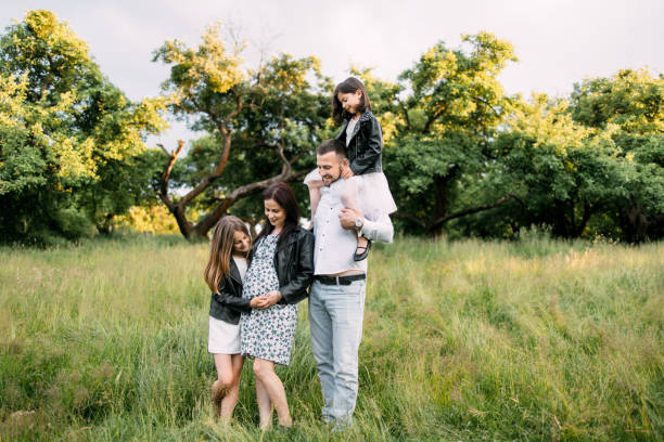istock Young parents with two kids posing among green garden 1328721933