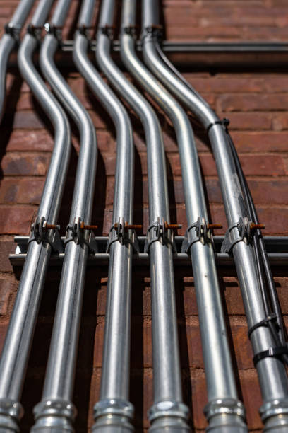 istock Electrical conduit pipes on a brick wall. 1328722138