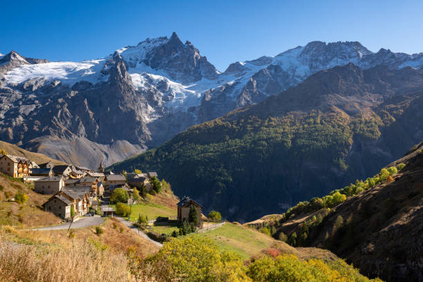 La Meije peak in Ecrins National Park with the village of Le Chazelet in Autumn. Hautes-Alpes, French Alps, France La Meije peak in Ecrins National Park with the village of Le Chazelet and glacier in Autumn. Hautes-Alpes (05), French Alps, France hautes alpes photos stock pictures, royalty-free photos & images