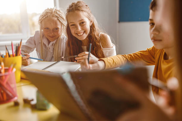 istock Smiling children studying at school and sitting at the table 1328727370