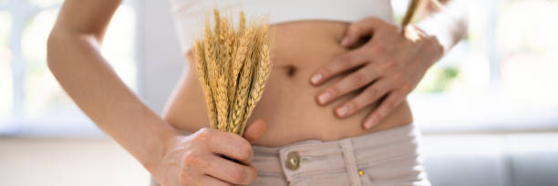 Celiac Disease And Gluten Intolerance Celiac Disease And Gluten Intolerance. Women Holding Spikelet Of Wheat food allergies stock pictures, royalty-free photos & images