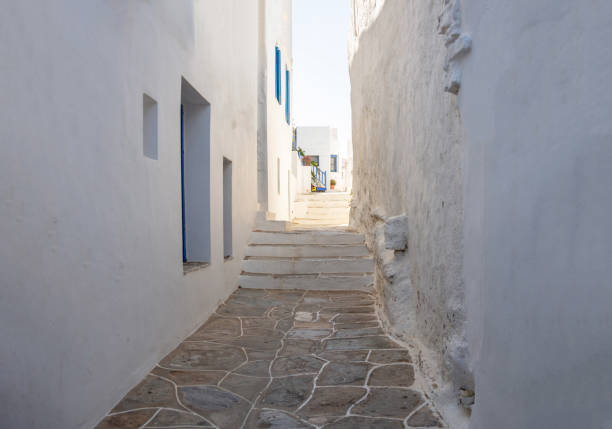 istock Whitewashed buildings cobblestone alley background at Sifnos island, Greece. 1328728647