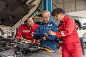 Senior professional mechanic use an obd2 car diagnostics device scanner to interpreting automotive error codes