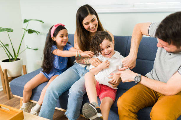 istock Playful hispanic family tickling her small son 1328730271