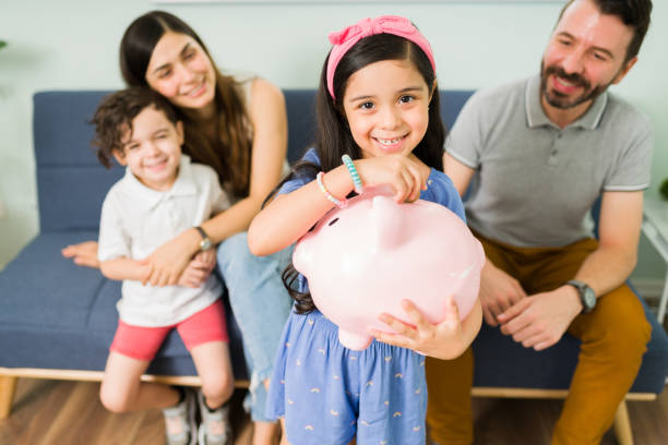 istock Adorable daughter saving for a family vacation 1328730562