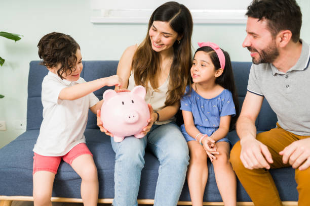 istock Happy mom, dad and kids saving money 1328730573