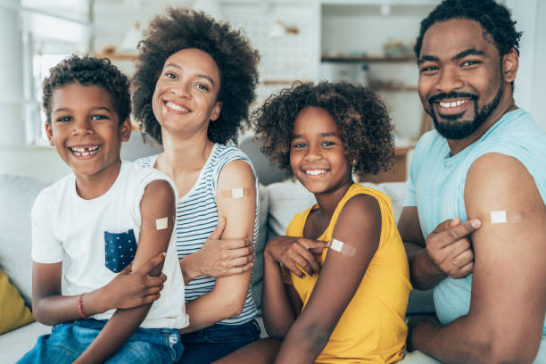 Portrait of a vaccinated family Portrait of family after getting covid-19 vaccine adhesive bandage stock pictures, royalty-free photos & images