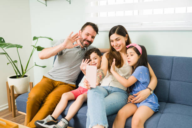 istock Latin mom, dad and kids during a video call 1328730762