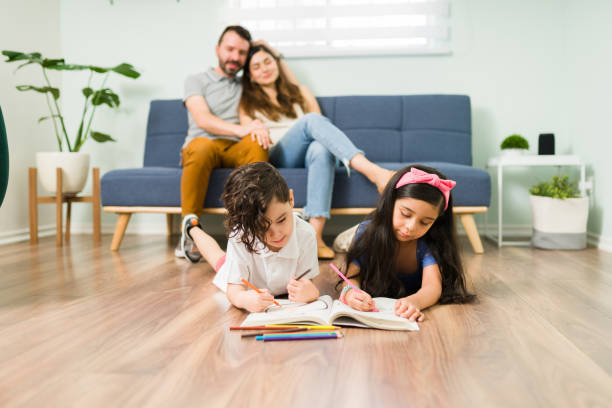 istock Satisfied mom and dad looking at their kids playing 1328731415