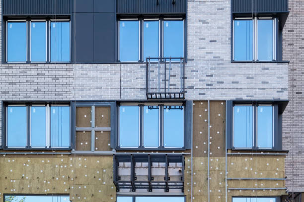 Installation of external wall thermal insulation with rock wool. Exterior passive house wall heat insulation with mineral wool. Insulation facade of multistory residential building. Energy efficiency