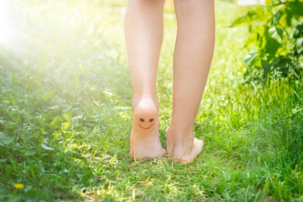 Baby feet barefoot close-up on the grass outdoors in sunlight