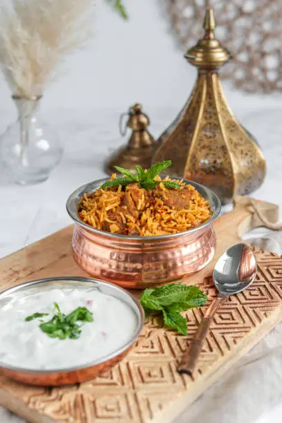 Traditional Lamb Biriyani mutton with yogurt dip raita for eid celebration