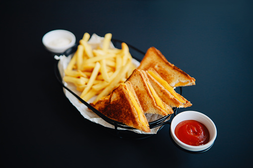Toast with cheese and french fries on the table in the restaurant.