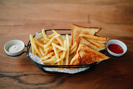 Toast with cheese and french fries on the table in the restaurant.