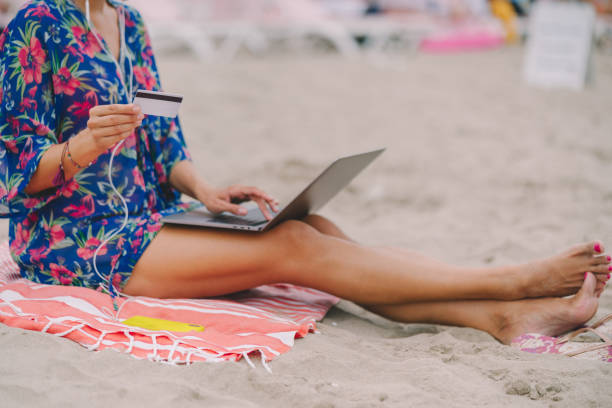 istock Woman using credit card at the beach 1328735350