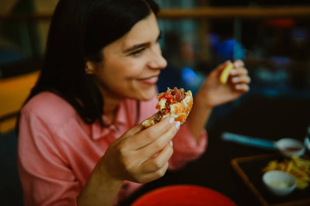 istock Woman eating in the burger restaurant 1328735532