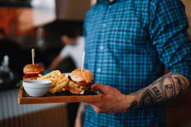 istock Young man bringing food in the burger restaurant 1328736675