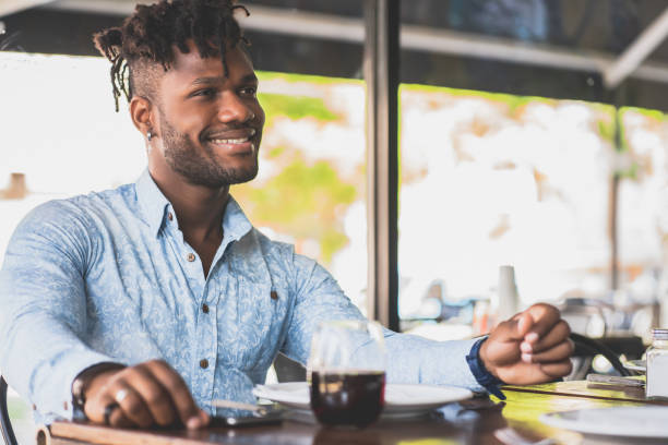 istock Young man sitting at a restaurant. 1328739408