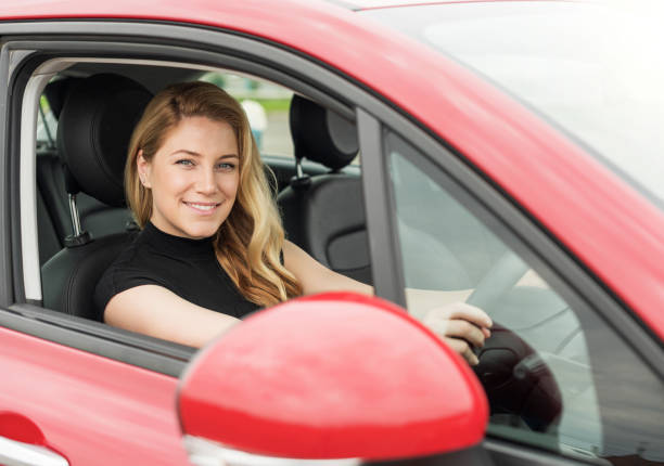 istock Happy beautiful woman drives a car. 1328741617