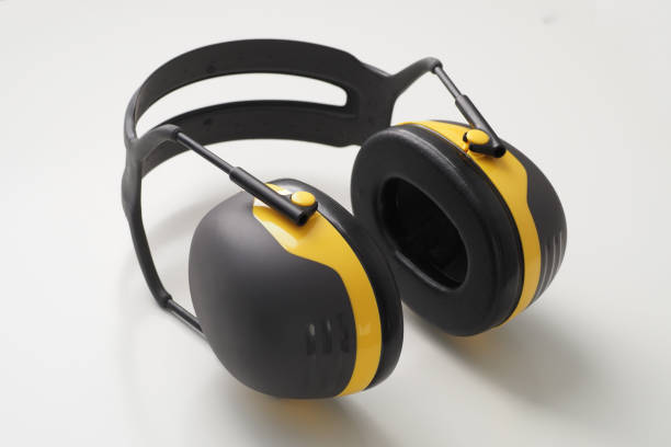 istock Yellow ear muffs on white desk. Protective headphones. 1328744029