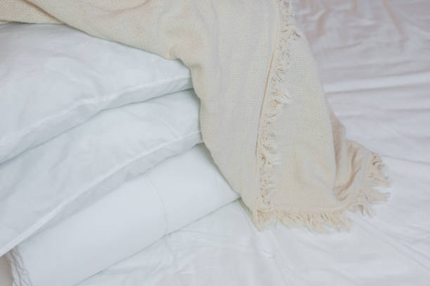istock stack of white pillows and blankets lies on the bed on a white sheet on top, covered with a blanket 1328744506