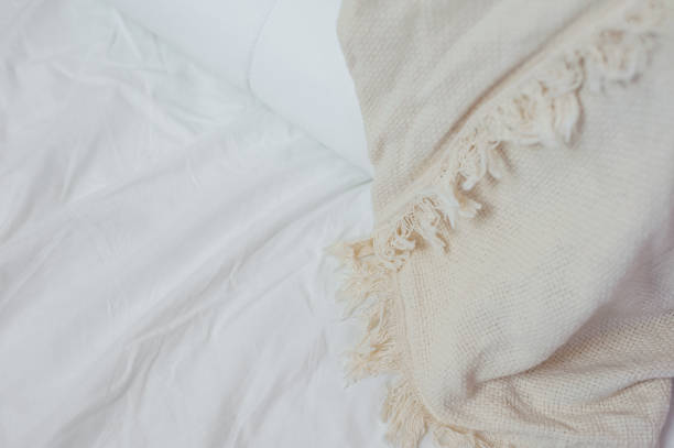 istock stack of white pillows and blankets lies on the bed on a white sheet on top, covered with a blanket 1328745111