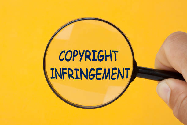 Copyright Infringement Concept Hand holding magnifying glass over copyright infringement word intellectual property photos stock pictures, royalty-free photos & images
