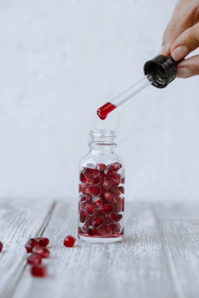 istock Woman Dripping Pomegranate Seed Oil 1328749717