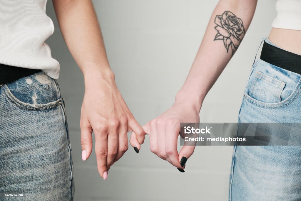 Closeup Of Unrecognizable Lesbians Holding Pinkie Fingers Together As