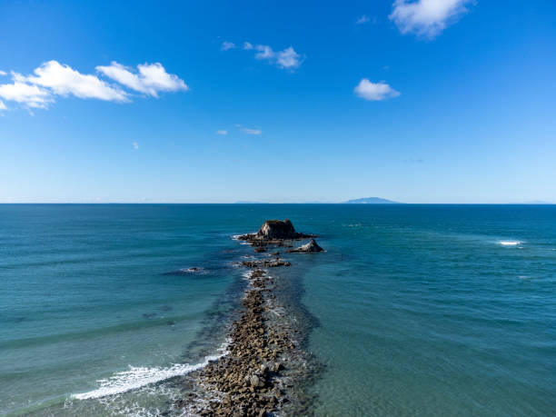 an aerial view of Mangawhai Heads breakwater at the entrance of the estuary