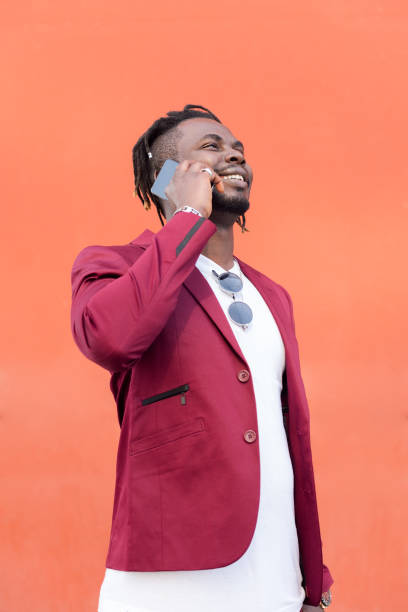 istock stylish african man laughing and talking on phone 1328765270