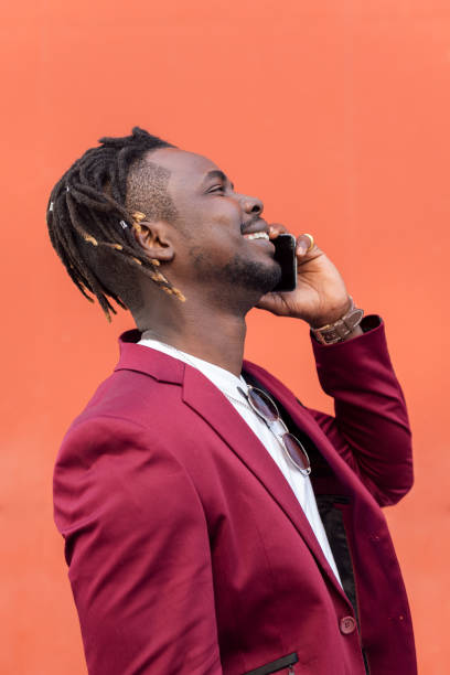 istock stylish african man laughing and talking on phone 1328765277