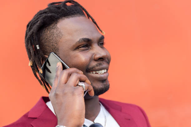 istock stylish black man smiling and talking on phone 1328765278