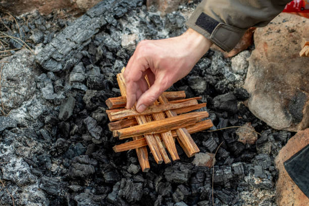 istock Starting the camp fire with kindling. Camping life. 1328772648