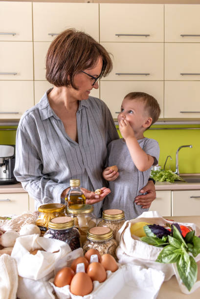 istock Adult mother feeds her son with nuts in the kitchen. 1328772694