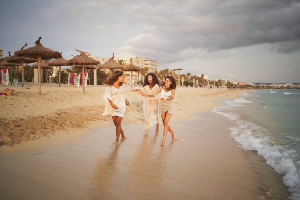 Three cheerful sisters dressed in white running and playing on beach Three cheerful sisters dressed on white running and playing at beach pinus pinea photos stock pictures, royalty-free photos & images