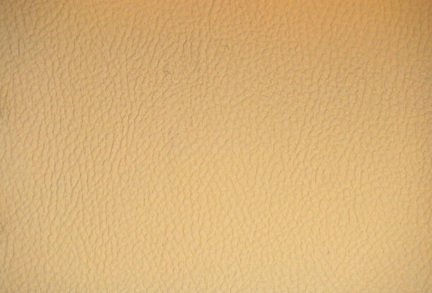 A fragment of genuine beige leather of high-quality workmanship with a characteristic pattern. Background, pattern, texture.