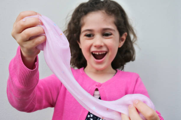 Happy young girl playing  with slime toy