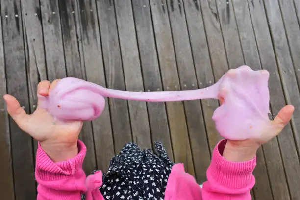 Photo of Young girl playing  with slime toy