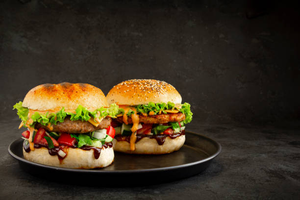 istock Two Fresh tasty burgers on dark background 1328781087