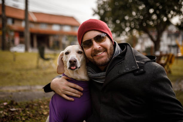 istock Pet owner smiling and hugging his dog 1328782783