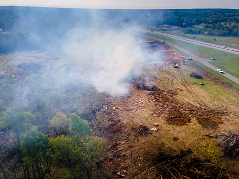 Trees being burned after they were chopped down and cleared away, causing smoke to fill the sky.  Images taken from an aerial perspective
