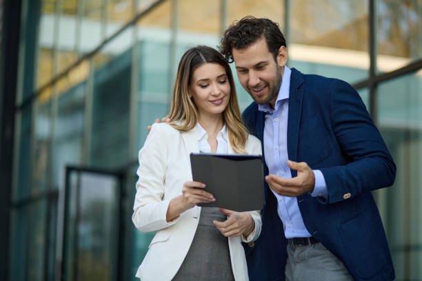 istock Business couple working online outdoors on a tablet computer 1328787605