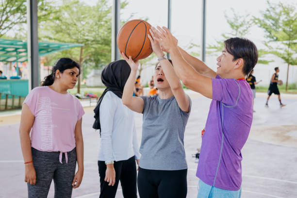 istock Asian basketball coach explaining techniques to his team members 1328791426