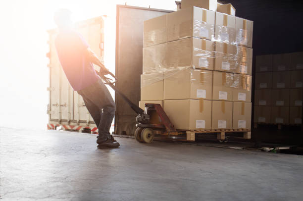 istock Warehouse Worker Unloading Package Box Out of The Inside Cargo Container. Truck Parked Loading at Dock Warehouse. Delivery Service. Shipping Warehouse Logistics. Freight Truck Transportation. 1328797027