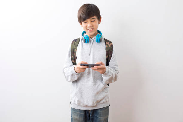 istock Asian teen boy student using smartphone isolate on white background. 1328797065